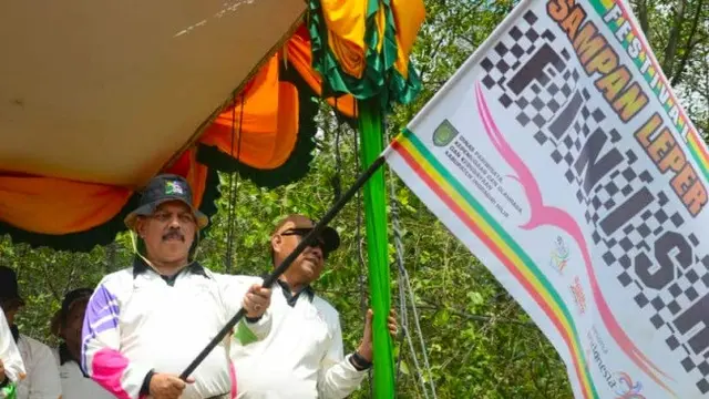 Panitia Festival Sampan Leper di Indragiri Hilir mengangkat bendera sebagai tanda dimulainya lomba