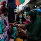 Pengunjung membeli busana muslim yang dijual di Pasar Tanah Abang, Jakarta Pusat, Minggu (2/5/2021). Pusat Grosir Pasar Tanah Abang ramai didatangi pengunjung yang berbelanja menjelang Lebaran dengan berdesak-desakan tanpa jaga jarak. (Liputan6.com/Johan Tallo)