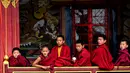 Seorang biksu Buddha muda menikmat teh paginya saat bersama biksu lainnya. Menurut kebiasaan masa lalu, dalam keluarga dengan tiga anak laki-laki, anak laki-laki tengah wajib militer ke biara dan dalam keluarga dengan dua anak laki-laki, anak bungsu dilantik ke dalam biara. (AFP/Arun Sankar)