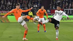 Pemain Belanda, Marten de Roon, berebut bola dengan pemain Jerman, Serge Gnabry, pada laga UEFA Nations League di Veltins Arena, Gelsenkirchen, Senin (19/11/2018). Kedua tim bermain imbang 2-2. (AP/Martin Meissner)