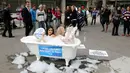 Sejumlah pengguna jalan melihat aksi kampanye aktivis wanita dari PETA yang mandi dengan busa di Jalan Paulista di Sao Paulo, Brasil, Selasa (2/8). Aksi itu untuk mengajak masyarakat beralih ke pola makan vegetarian. (REUTERS/Paulo Whitaker)
