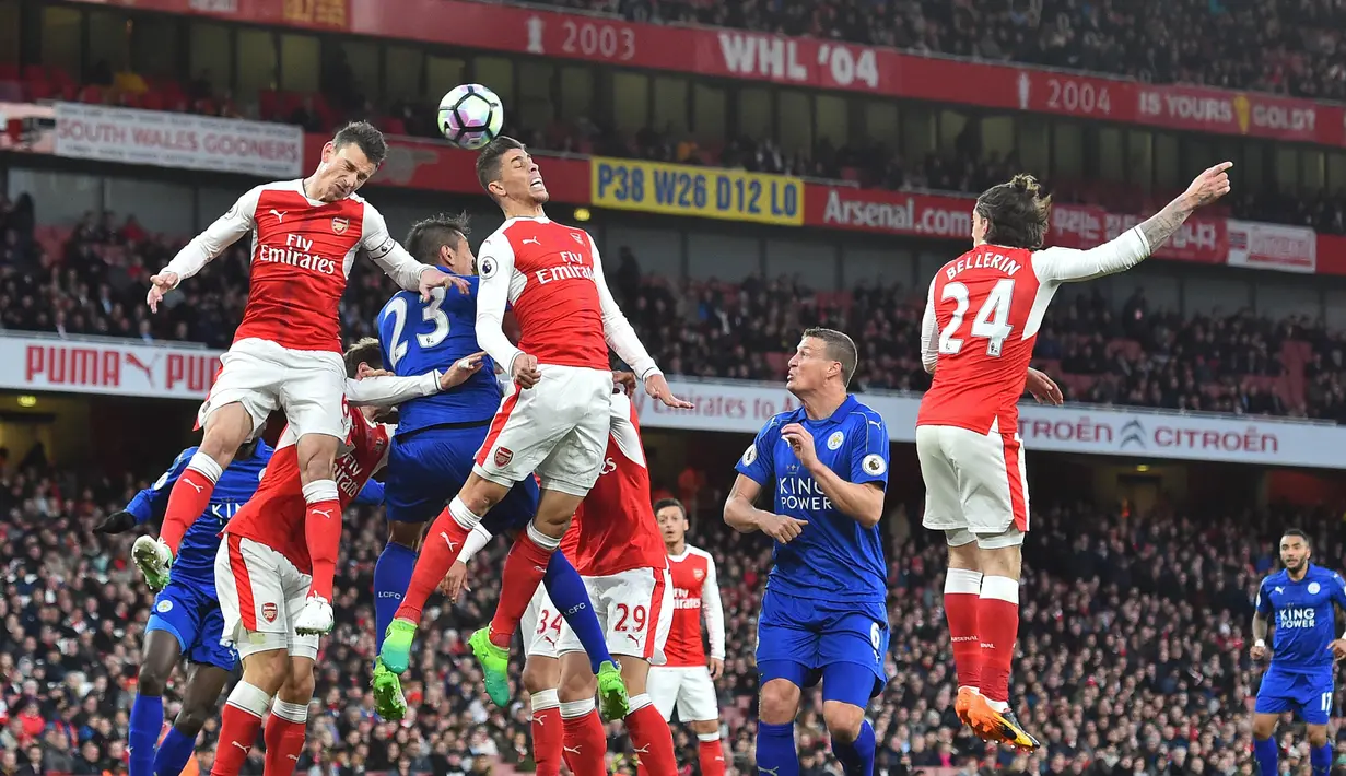 Para pemain Arsenal dan Leicester melakukan duel udara pada laga Premier League di Stadion Emirates, London, Rabu (26/4/2017). Arsenal menang 1-0 atas Leicester. (AFP/Glyn Kirk)