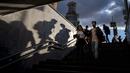 Orang-orang berjalan ke underpass di bawah jalan saat matahari terbenam di Moskow, Rusia, Selasa (15/9/2020). (AP Photo / Alexander Zemlianichenko)