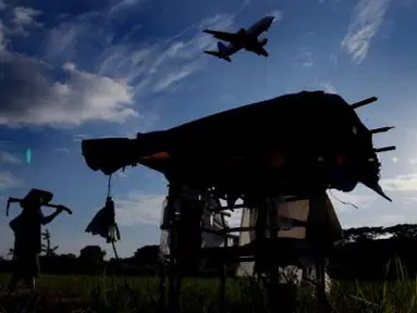 Seorang petani melihat pesawat saat akan landas di landasan Bandara Internasional Sultan Hasanuddin Makassar, Sulsel, Selasa (10/4). Bandara Internasional Sultan Hasanuddin akan menambah lahan bandara sekitar 15.000 meter persegi, panjangnya menjadi 35.000 meter, juga membutuhkan pembebasan lahan 2.000 meter persegi. (Antara)