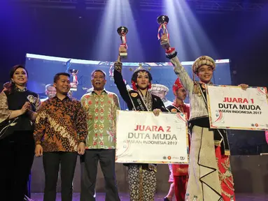 Wendra Tandribali dari DKI Jakarta dan Scholastika Asyana dari Provinsi DIY Putri mengangkat piala usai terpilih menjadi Duta Muda ASEAN-Indonesia 2017 di Balai Sarbini, Jakarta, Selasa (29/08). (Liputan6.com/Herman Zakharia)