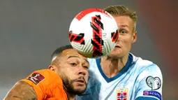 Pemain Norwegia Stian Gregersen (kanan) dan pemain Belanda Memphis Depay bersaing memperebutkan bola pada pertandingan sepak bola kualifikasi Grup G Piala Dunia 2022 di Stadion De Kuip, Rotterdam, Belanda, 16 November 2021. Belanda menang 2-0. (AP Photo/Peter Dejong)