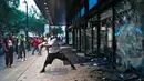 Pengunjuk rasa menghancurkan jendela di kantor pusat CNN di Atlanta, Georgia, Jumat (29/5/2020). Massa yang mengecam kematian George Floyd (46) oleh polisi melakukan vandalisme dan perusakan gedung CNN pusat. (Alyssa Pointer/Atlanta Journal-Constitution via AP)