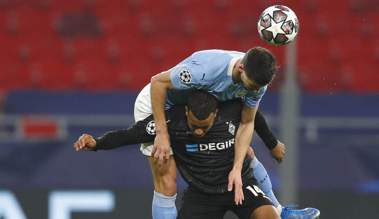 Pemain Manchester City, Ruben Dias, berebut bola dengan pemain Borussia Moenchengladbach, Alassane Plea, pada laga Liga Champions di Puskas Arena, Kamis (25/02/2021). City menang dengan skor 2-0. (AP/Laszlo Balogh)