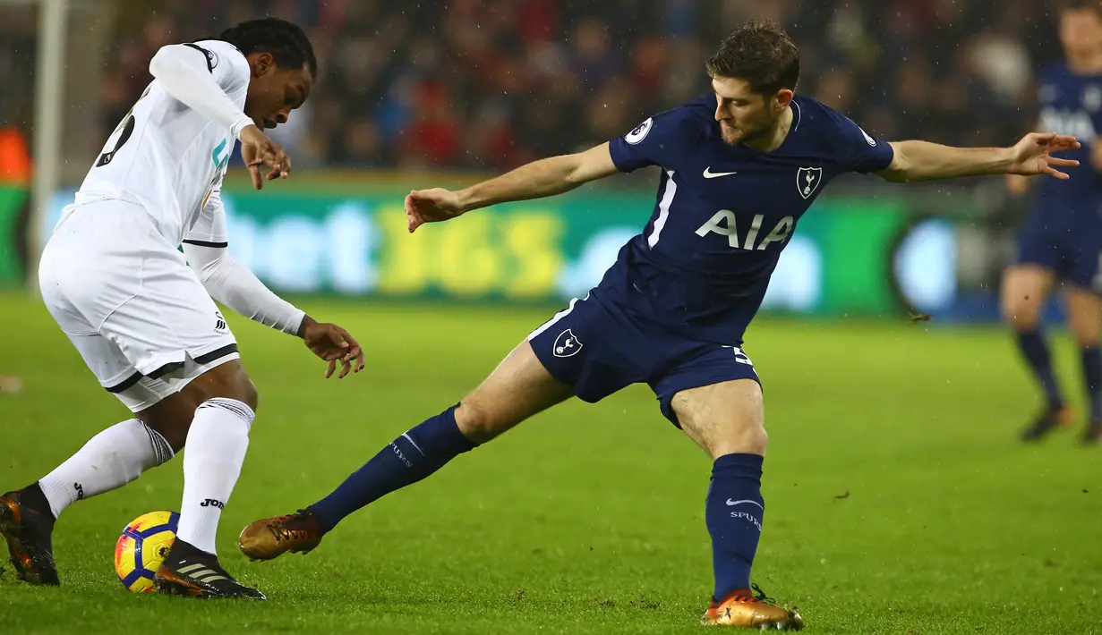 Pemain Swansea City, Renato Sanches (kiri) mencoba melewati adangan pemain Tottenham, Ben Davies pada lanjutan Premier League di The Liberty Stadium, Swansea, (2/1/2018). Tottenham menang 2-0. (AFP/Geoff Caddick)