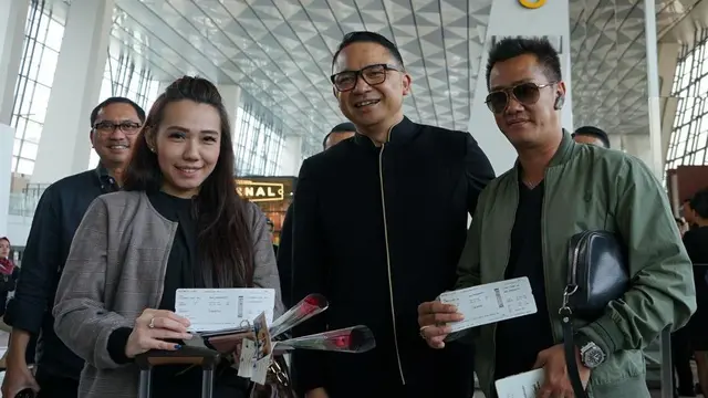 Peringati Hari Pelanggan Nasional, Garuda Indonesia, membagikan souvenir kepada penumpang GA 830 rute Jakarta – Singapura di Terminal 3 Bandara Internasional Soekarno Hatta.