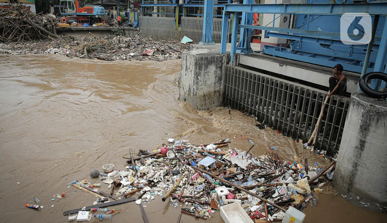 Warga mencari barang bekas dari tumpukan sampah di Pintu Air Manggarai, Jakarta, Senin (10/10/2022). Hujan lebat yang mengguyur wilayah Bogor dan sekitarnya menyebabkan debit air Sungai Ciliwung meningkat dan menghanyutkan sampah ke Pintu Air Manggarai. (Liputan6.com/Faizal Fanani)
