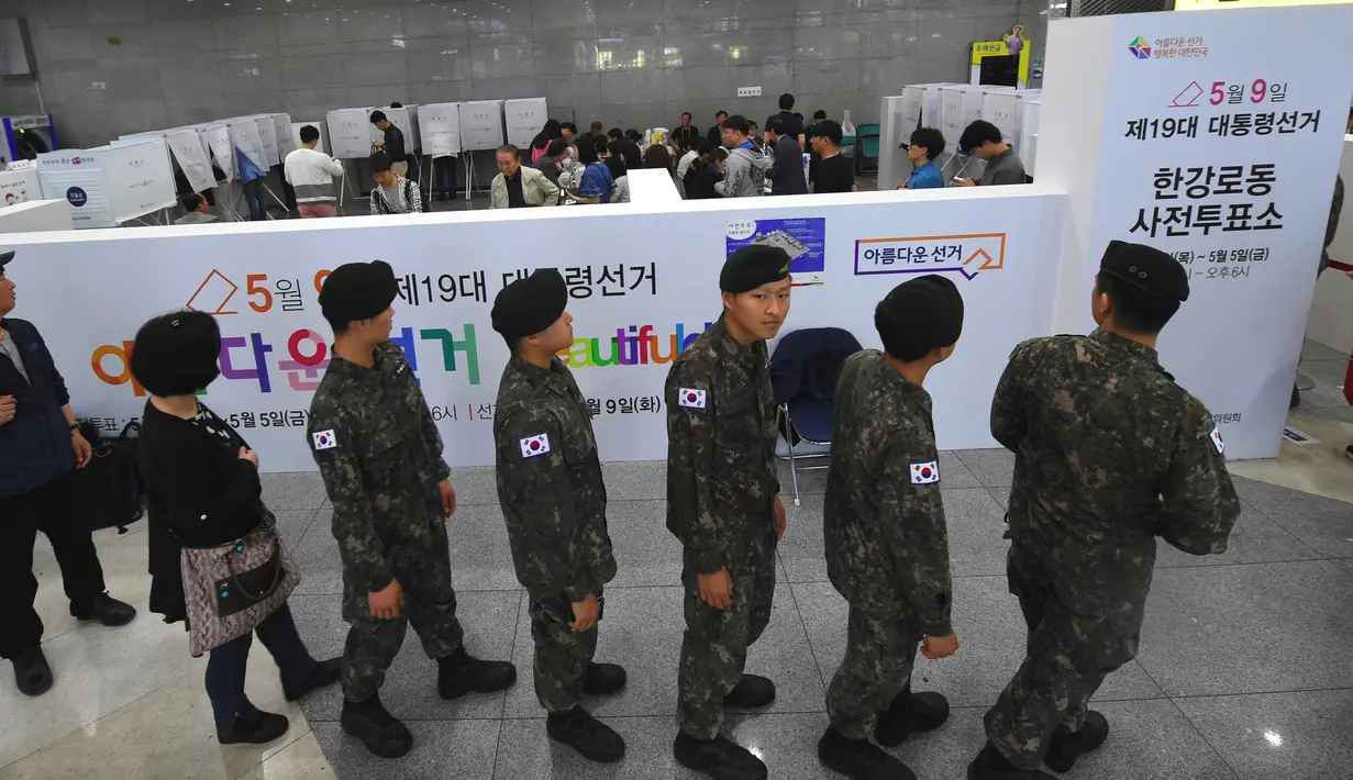 Tentara Korea Selatan (Korsel) keluar dari bilik suara di sebuah TPS di Seoul, Kamis (4/5). Mereka mulai memberikan suaranya dalam pemilihan presiden untuk mencari pengganti presiden terguling Park Geun-hye. (AP Photo/Lee Jin-man)