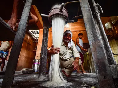Pekerja menyiapkan bihun yang digunakan untuk membuat hidangan manis tradisional yang populer dikonsumsi selama bulan suci Ramadhan, di sebuah pabrik di Allahabad, India (5/4/2022). (AFP/Sanjay Kanojia)