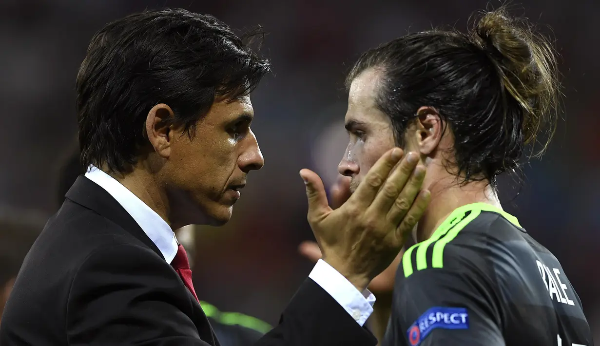 Pelatih Wales, Chris Coleman (kiri)  memberikan semangat kepada Gareth Bale usai kalah dari Portugal 0-2 pada semi-final Piala Eropa 2016 di Stadion Parc Olympique Lyonnais, DÈcines-Charpieu, Prancis, Kamis (7/7/2016) dini hari WIB. (AFP/Miguel Medina)