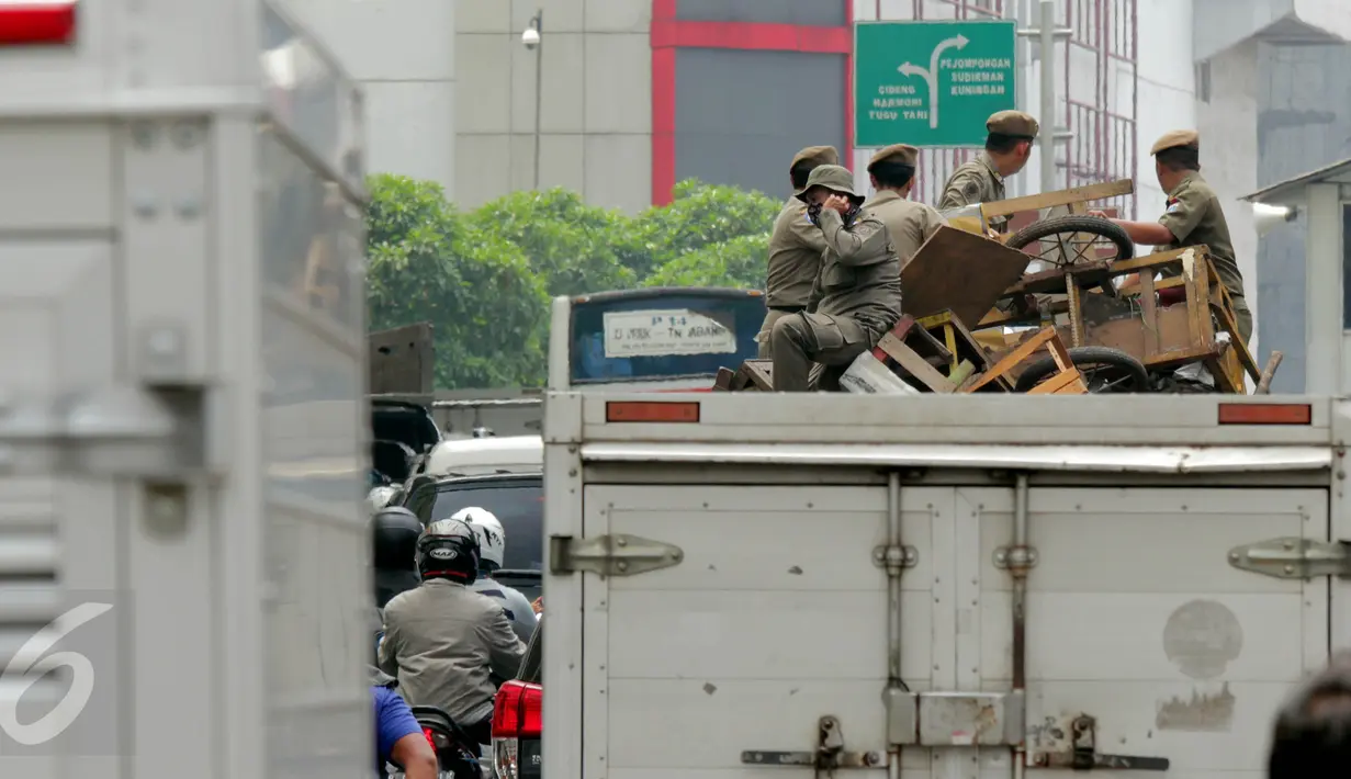 Petugas Satpol PP menertibkan dan mengangkut lapak pedagang kaki lima (PKL) di Pasar Tanah Abang, Jakarta, Kamis (4/5). Penertiban dilakukan agar tidak menggangu fungsi pedestrian untuk pejalan kaki. (Liputan6.com/Johan Tallo)
