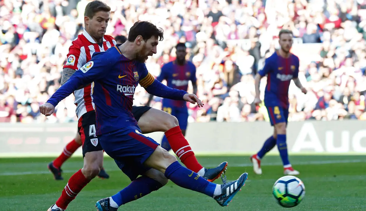 Lionel Messi mengumpan bola dari kawalan pemain Athletic Bilbao saat bertanding pada lanjutan La Liga Spanyol di stadion Camp Nou, (18/3). Pada pertandingan ini, Messi terlihat berjoget usai mencetak gol. (AP Photo/Manu Fernandez)