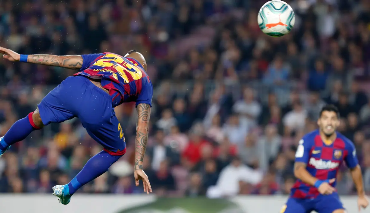 Gelandang Barcelona, Arturo Vidal menyundul bola saat menjamu Real Valladolid dalam pertandingan pekan ke-11 La Liga  di Camp Nou, Selasa (29/10/2019). Barcelona sukses merebut puncak klasemen La Liga pekan ini setelah menang telak dengan skor 5-1 atas Valladolid. (AP/Joan Monfort)