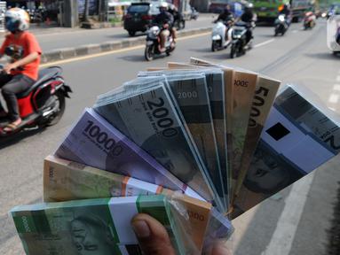 Penjual jasa penukaran uang menawarkan uang baru di kawasan Jalan Raya Parung, Bogor, Jawa Barat, Jumat  (7/5/2021). Penjual jasa yang marak jelang Idul Fitri tersebut banyak dijumpai di sejumlah jalan protokol. (merdeka.com/Arie Basuki)