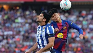 Gelandang Spanyol Barcelona #27, Pedro Fernandez "Dro", dan penyerang Portugal Real Sociedad #11, Goncalo Guedes, bersaing untuk mendapatkan sundulan selama pertandingan Liga Spanyol antara FC Barcelona dan Real Sociedad di Estadi Olimpic Lluis Companys di Barcelona pada 28 September 2025. (Josep LAGO/AFP)