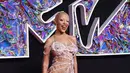 Doja Cat tiba di karpet merah MTV VMA mengenakan gaun putih rajutan dari Monse dengan detail seperti jaring laba-laba. Dia melengkapi ansambelnya dengan perhiasan berlian dari Maria Tash dan Nicole Rose. [@upscalemagazine]