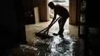 Padli, 39 tahun, membersihkan sisa material banjir berupa lumpur dari rumahnya di Aceh Tamiang, pada Minggu 14 Desember 2025. Sebagian warga yang tinggal di Aceh Tamiang, Aceh, mulai membersihkan rumah dari lumpur, sisa material banjir bandang yang menerjang wilayah mereka, akhir November 2025 lalu. (Yasuyoshi CHIBA/AFP)
