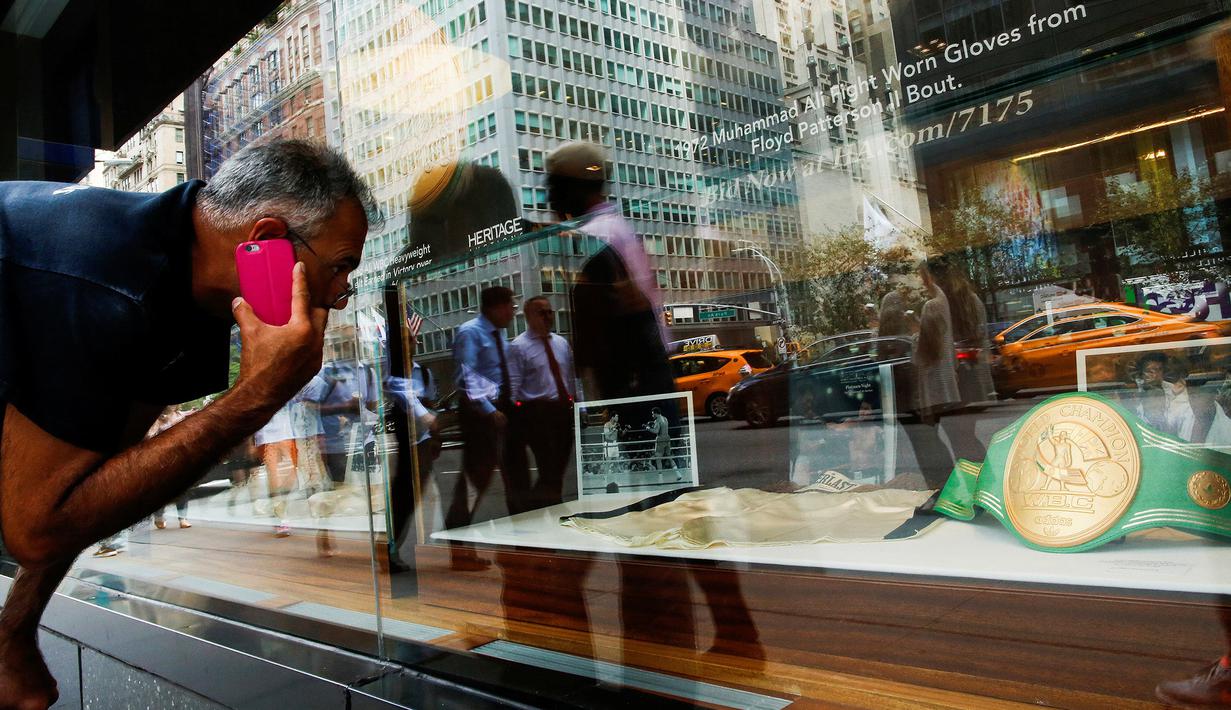 Warga melihat barang-barang Muhammad Ali yang akan dilelang di Heritage Auctions, New York, AS, (19/8). Sabuk juara WBC Muhammad Ali diharapkan dapat terjual dengan nilai lebih dari 1 juta poundsterling sekitar Rp 17 miliar. (REUTERS/Eduardo Munoz)