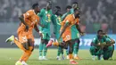 Sejumlah pemain Pantai Gading merayakan kemenangan atas Senegal pada babak 16 besar Piala Afrika 2023 di Stade Charles Konan Banny, Yamoussoukro, Selasa (30/01/2024) dini hari WIB. Pantai Gading menang dengan skor 5-4 pada babak adu penalti. (AFP/Kenzo Tribouillard)