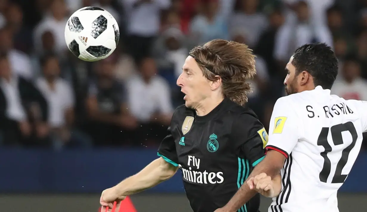 Gelandang Real Madrid, Luka Modric, berebut bola dengan bek Al-Jazira, Salem Rashid, pada laga semifinal Piala Dunia Antarklub 2017 di Stadion Zayed Sport City, Rabu (13/12/2017). Real Madrid menang 2-1 atas Al-Jazira. (AFP/Karim Sahib)
