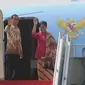 Presiden Jokowi dan Iriana melambaikan tangan dari tangga pesawat Kepresiden RI. 