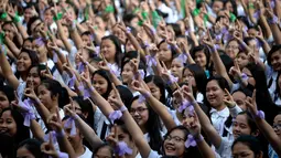 Siswa St. Scholastica College mengacungkan jari telunjuk "nomor satu" saat menari massal dalam aksi One Billion Rising di Filipina, Senin (15/2). Gerakan ini bentuk kampanye untuk menghentikan kekerasan terhadap perempuan. (AFP PHOTO/Noel CELIS)