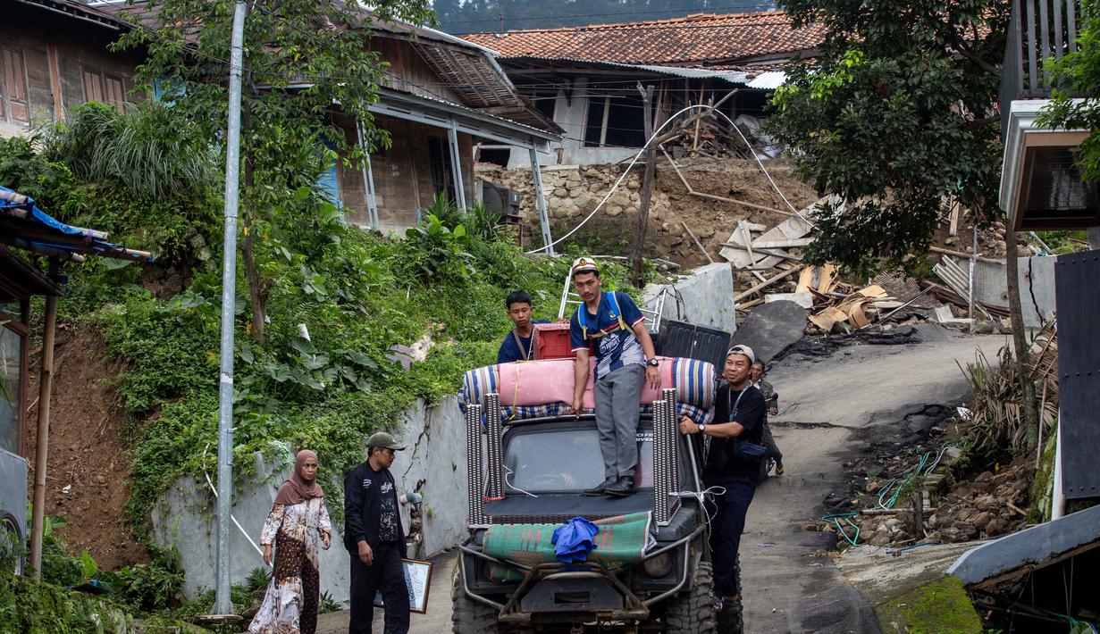 Pemerintah Kabupaten Tegal juga telah menetapkan status Tanggap Darurat Bencana Tanah Bergerak hingga 16 Februari 2026. Tampak dalam foto, warga menyelamatkan barang-barang mereka setelah pergerakan tanah melanda permukiman mereka di desa Padasari, Tegal, Jawa Tengah, Senin 9 Februari 2026. (DEVI RAHMAN/AFP)