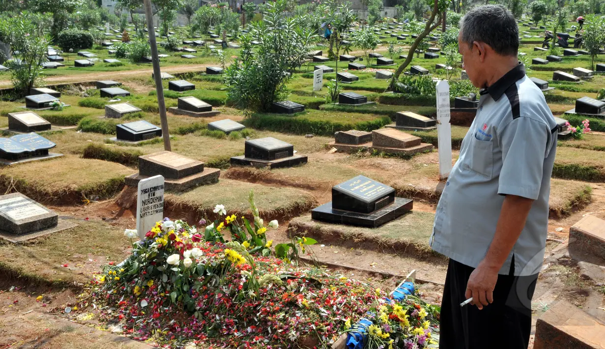 Makam almarhum Olga Syahputra banjir dengan aneka bunga, Jakarta, Senin (30/3/2015). Tampak seorang penjaga makam memperlihatkan kondisi makam Olga yang penuh dengan bunga (Liputan6.com/Panji Diksana)