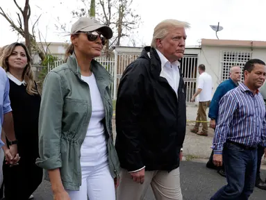 Presiden AS Donald Trump dan ibu negara Melania Trump ditemani Gubernur Puerto Rico, Ricardo Ricardo Rosselló berkeliling ke permukiman warga di Guaynabo, Selasa (3/10). Trump meninjau kerusakan yang diakibatkan Badai Maria dua pekan lalu. (AP/Evan Vucci)