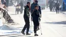 Rateb Mahmoud Qaliq sempat menggunakan kaki palsu, namun ia jarang menggunakannya karena tidak nyaman. Rateb Mahmoud Qaliq merasa nyaman menggunakan kruk karena lebih ringan. Tampak dalam foto, Rateb Mahmoud Qaliq (kiri) bersam rekannya di Deir al-Balah, di Jalur Gaza tengah, pada 3 Desember 2025. (Bashar Taleb/AFP)
