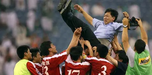 Pelatih Korea Utara, Kim Jong Hun bersama para pemainnya merayakan keberhasilan lolos ke Piala Dunia 2010 Afrika Selatan, setelah bermain 0-0 dengan Saudi Arabia pada 17 Juni 2009 di Riyadh. AFP PHOTO/MIDO AHMED