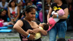 Seorang wanita menyusui bayinya saat mengikuti acara promosi manfaat menyusui, di sebuah taman di Bogota, Kolombia(3/11). Ratusan ibu menyusui bayi mereka untuk mempromosikan pemberian ASI sebagai bagian dari hak bayi. (AFP Photo/Raul Arboleda)