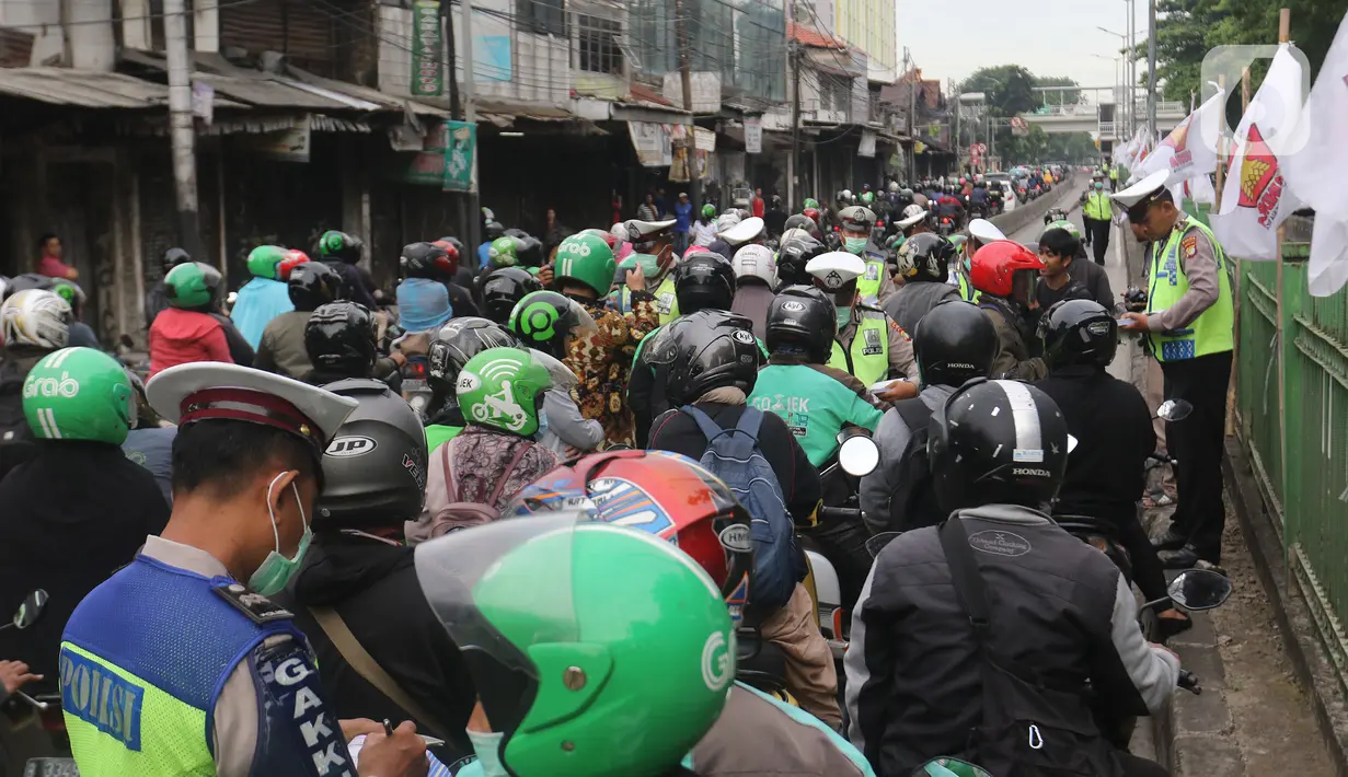Polisi menilang pengendara sepeda motor yang menerobos jalur Transjakarta di Jalan Sultan Agung, Manggarai, Jakarta, Rabu (12/2/2020). Pengendara kerap melintasi jalur Transjakarta untuk menghindari kemacetan lalu lintas. (Liputan6.com/Herman Zakharia)