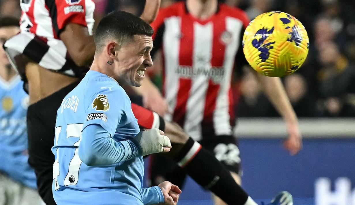 Pemain Manchester City, Phil Foden, mencetak gol melalui tandukan kepala ke gawang Brentford pada laga Liga Inggris di Stadion Gtech Community, Selasa (6/2/2024). Foden memborong tiga gol. (AFP/Ben Stansall)