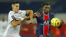 Penyerang Paris Saint-Germain (PSG), Moise Kean, berebut bola dengan pemain Renners, Nayef Aguerd, pada laga Liga Prancis di Stadion Parc des Princes, Sabtu (7/11/2020). PSG menang dengan skor 3-0. (AP/Christophe Ena)