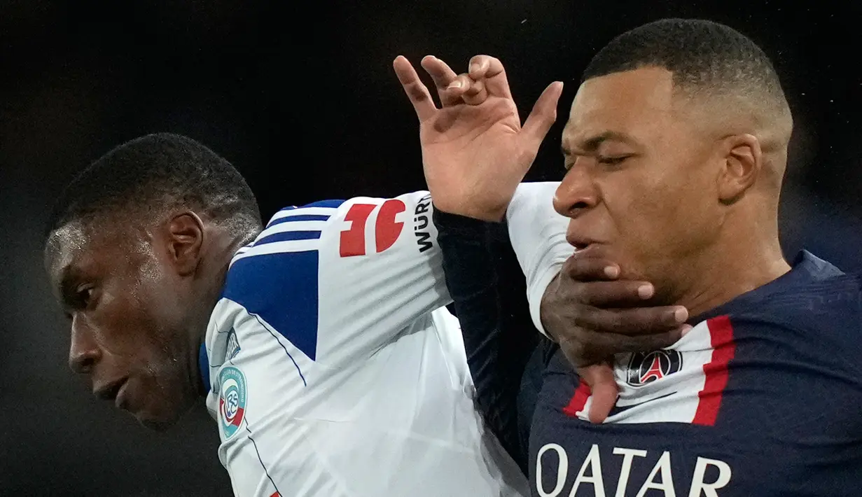 Pemain Paris Saint-Germain (PSG) Kylian Mbappe (kanan) berduel memperebutkan bola dengan pemain Strasbourg Jean-Ricner Bellegarde pada pertandingan sepak bola Liga Prancis di Parc des Princes, Paris, Prancis, 28 Desember 2022. PSG mengalahkan Strasbourg dengan skor 2-1. (AP Photo/Thibault Camus)