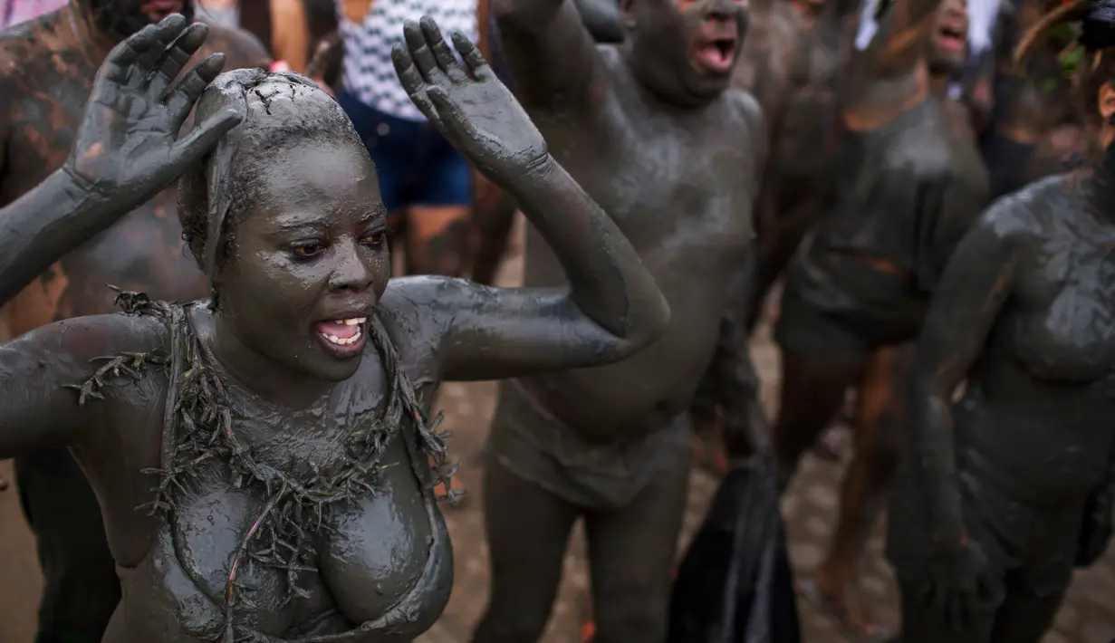 Peserta dengan tubuh yang dipenuhi lumpur menari saat mengikuti festival tradisional "Bloco da Lama" atau "Mud Street" di Paraty, Brasil (25/2). Festival ini diikuti mulai dari masyarakat sekitar sampai turis asing. (AP Photo / Mauro Pimentel)