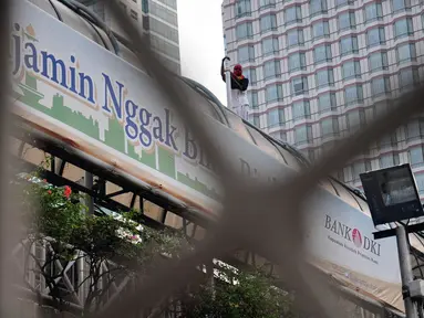 Mengaku kecewa pada hasil Pilpres 2014, seorang pria tidak dikenal berdiri di atas JPO di sekitar Bundaran HI, Jakarta, (25/7/2014). (Liputan6.com/Faizal Fanani)
