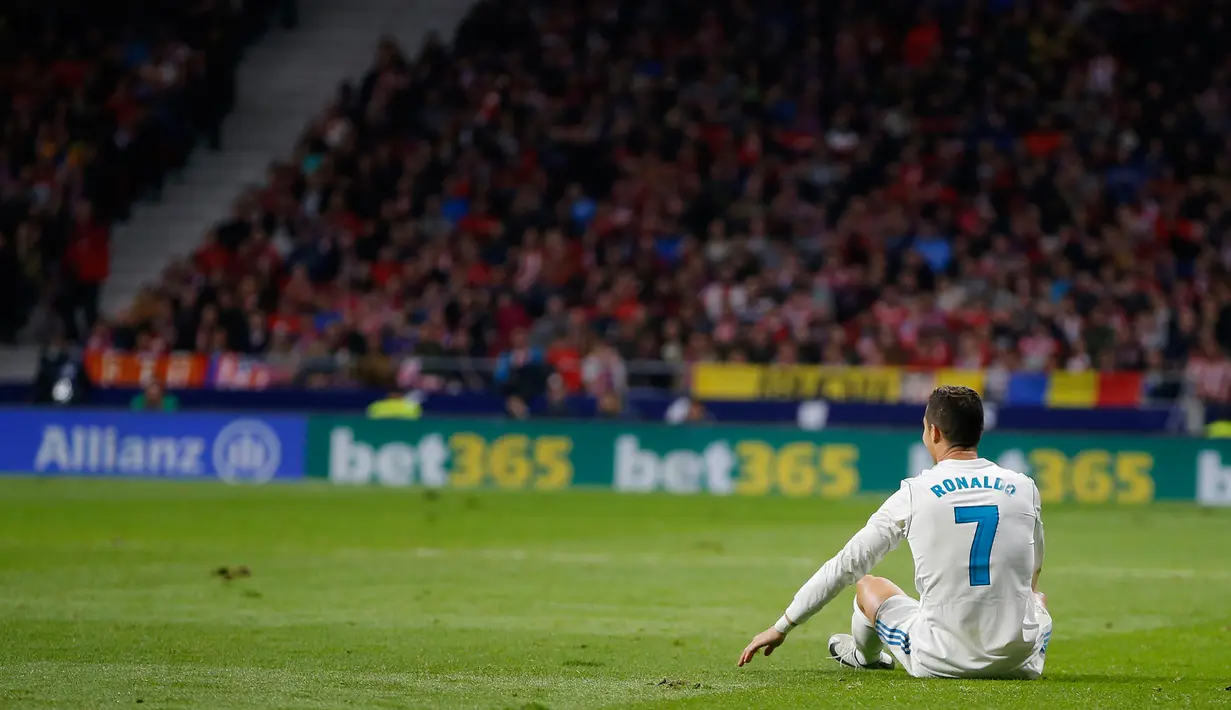 Pemain Real Madrid, Cristiano Ronaldo duduk di lapangan saat laga pekan ke-12 La Liga kontra Atletico Madrid di Stadion Wanda Metropolitano, Sabtu (18/11). Laga Derbi Madrid itu berakhir imbang tanpa gol. (AP/Paul White)