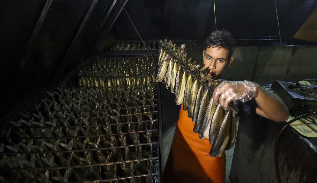 <p>Seorang pemuda Palestina bekerja di fasilitas pengasapan makarel saat ikan itu akan dijual jelang liburan Idul Fitri di Rafah di Jalur Gaza selatan (26/4/2022). Ikan asap makarel menjadi salah satu menu hidangan buka puasa dan Idul Fitri terfavorit bagi warga Gaza selama Ramadhan.(AFP/Said Khatib)</p>