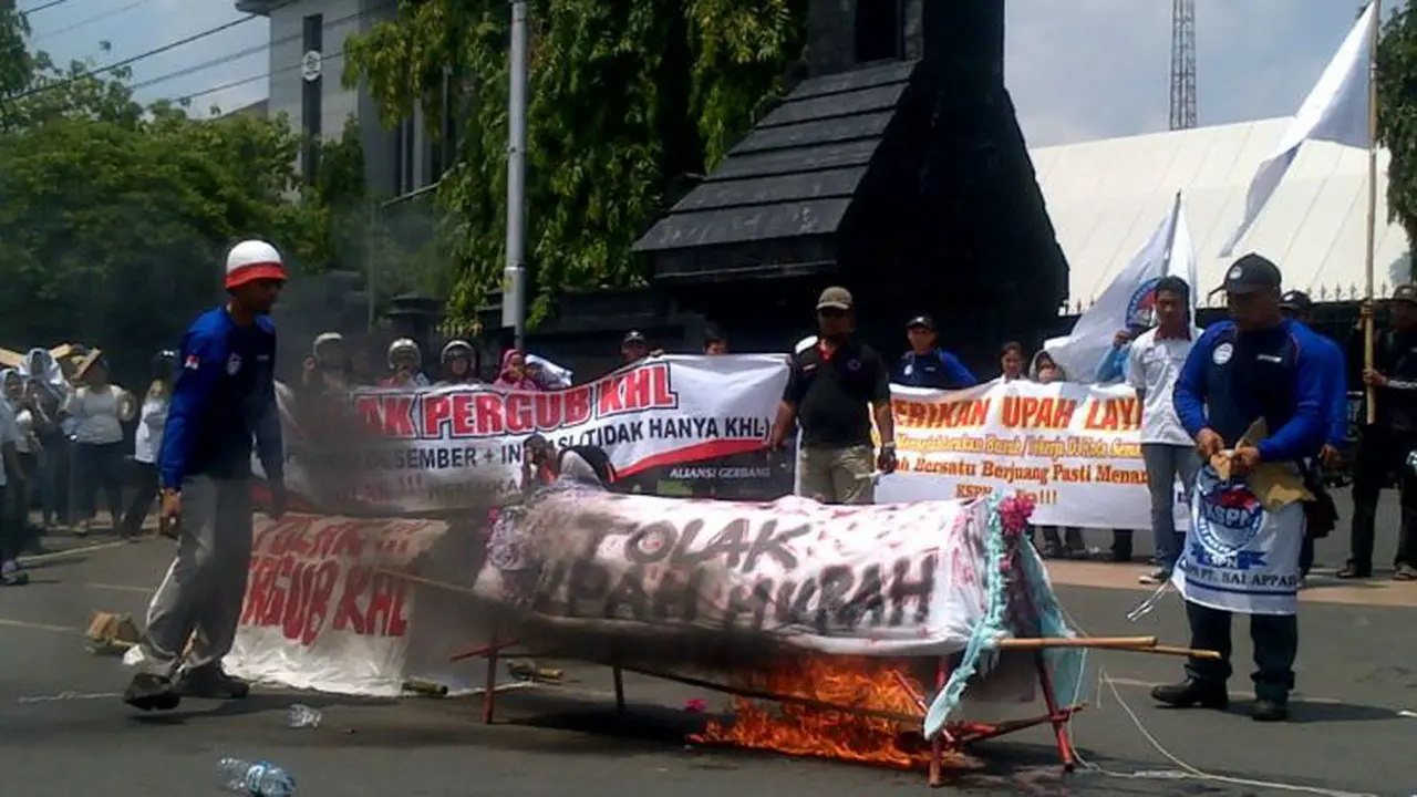 Para buruh membakar keranda, selasa (18/11/2014) di depan kantor gubernur Jateng.