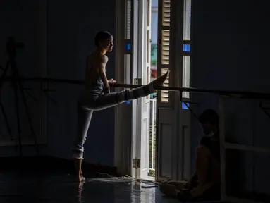 Seorang penari Balet Nasional Kuba melakukan peregangan sebelum berlatih di sekolah balet di Havana, Kuba, Selasa (5/4/2022). Balet Nasional Kuba memulai latihan untuk kembali ke panggung setelah lebih dari setahun setelah pandemi COVID-19 ditutup. (AP Photo/Ramon Espinosa)