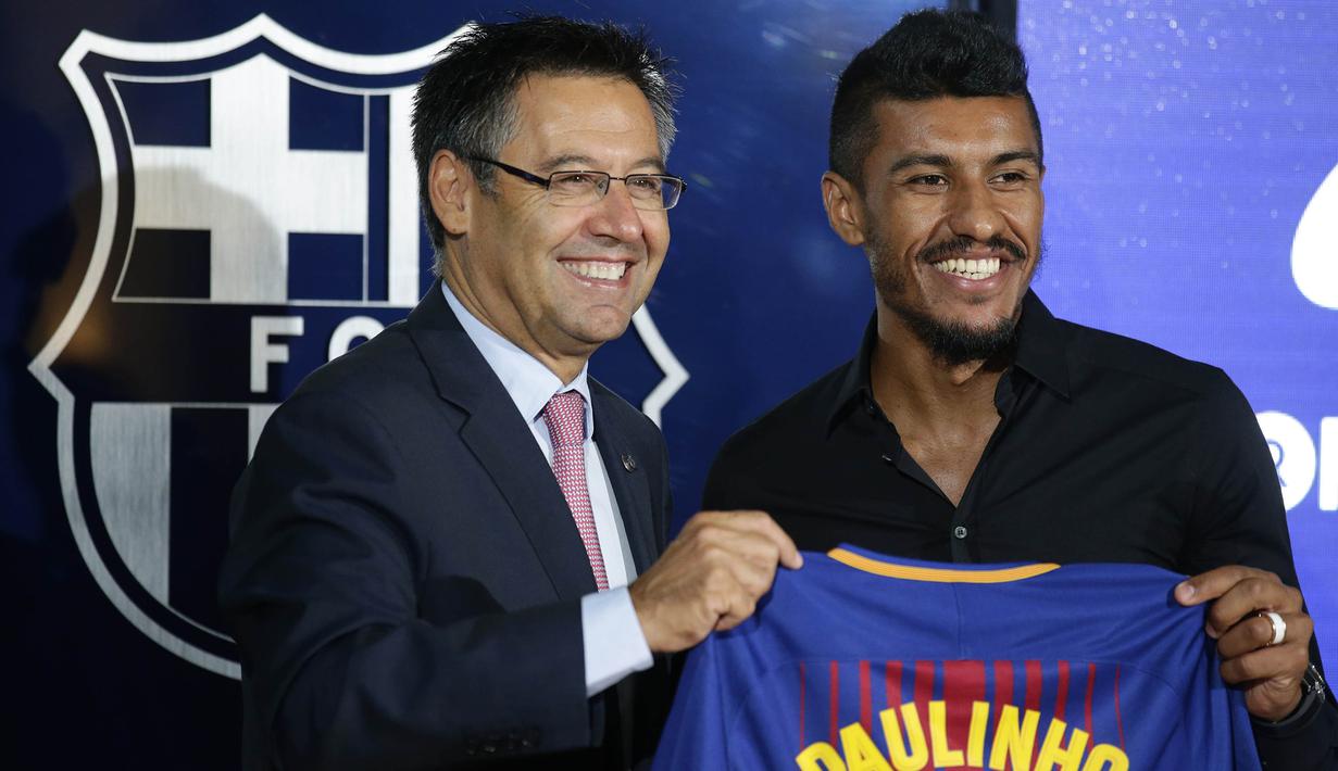 Presiden Barcelona, Josep Maria Bartomeu, foto bersama pemain baru Barcelona, Paulinho, di Stadion Camp Nou, Kamis (17/7/2017). Pria asal Brasil ini resmi berseragam Barcelona setelah ditebus dari Guangzhou Evergrande. (AP/Manu Fernandez)