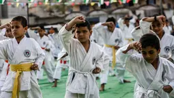 Anak-anak Palestina menunjukkan keterampilannya selama upacara promosi Karate di sebuah pusat olahraga di kamp Rafah untuk pengungsi Palestina di Jalur Gaza selatan (20/9/2019). (AFP Photo/Said Khatib)