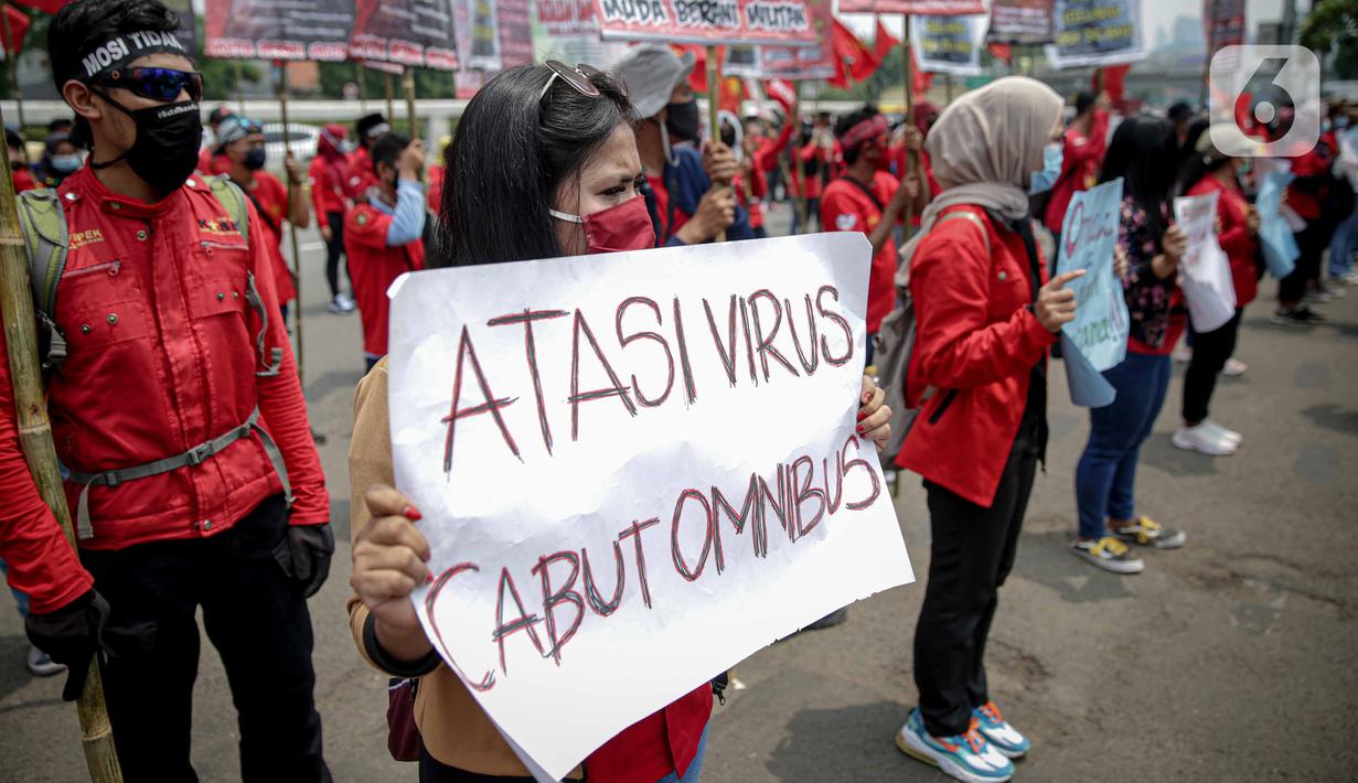 Massa buruh membawa poster saat menggelar unjuk rasa di depan Kompleks Gedung DPR/MPR, Jakarta, Selasa (17/11/2020). Buruh kembali menggelar aksi lanjutan menuntut pemerintah dan DPR untuk mencabut Omnibus Law Undang-Undang Cipta Kerja. (Liputan6.com/Faizal Fanani)