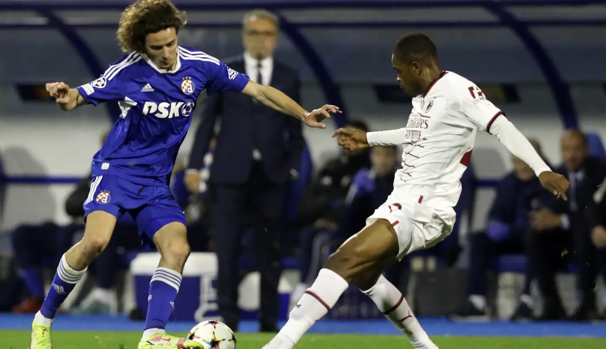 Gelandang Dinamo Zagreb, Robert Ljubicic dan bek AC Milan Pierre Kalulu bersaing pada pekan ke-5 Grup E Liga Champions 2022/2023 di Stadion Maksimir, Rabu (26/10/2022) dini hari WIB. Gol-gol dari Matteo Gabbia, Rafael Leao, penalti Olivier Giroud , dan gol bunuh diri Robert Ljubicic membantu AC Milan semakin dekat dengan tiket lolos ke babak 16 besar. (AP Photo)